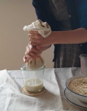 Abseihen und Filtern von selbstgemachter Hafermilch