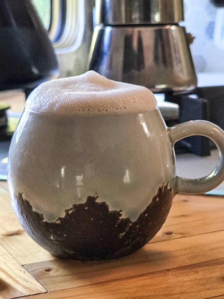 Aufgeschäumter Haferdrink in einem Kaffeebecher